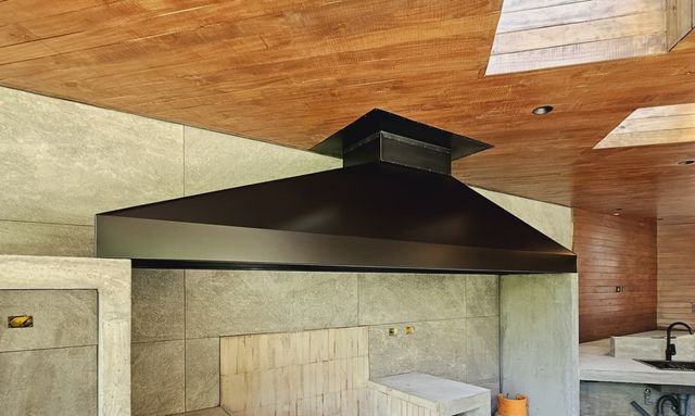 Campana piramidal negra bajo techo de madera