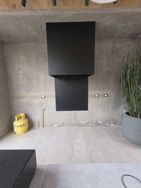 Campana rectangular de doble volumen sobre un muro de hormigón visto