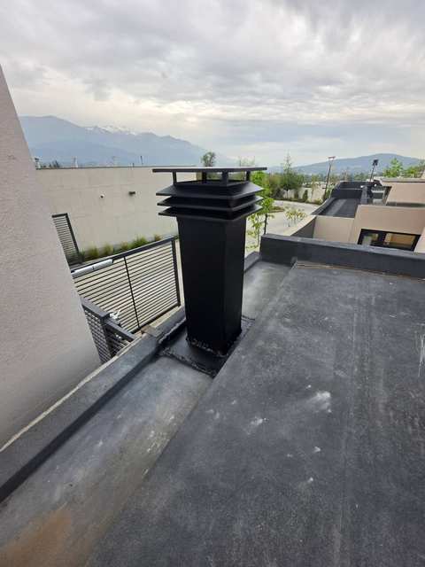 Sombrerete negro de la campana en el techo, con la cordillera al fondo