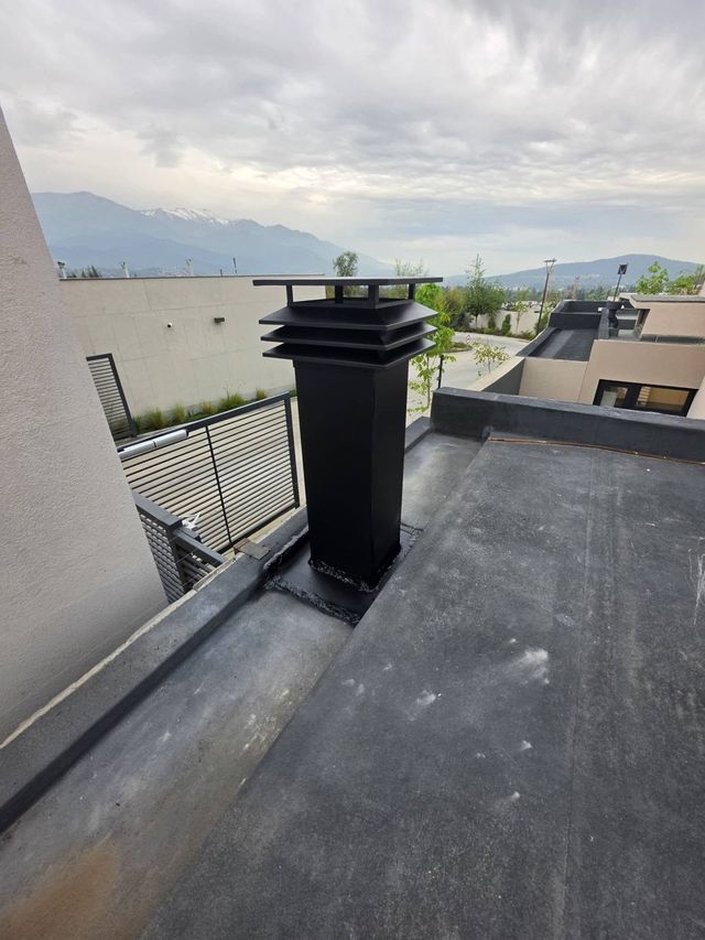 Sombrerete negro de la campana en el techo, con la cordillera al fondo