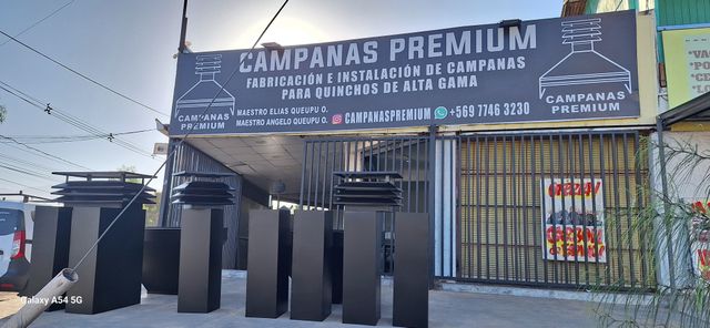 Fachada del taller con letrero y campanas listas para despacho