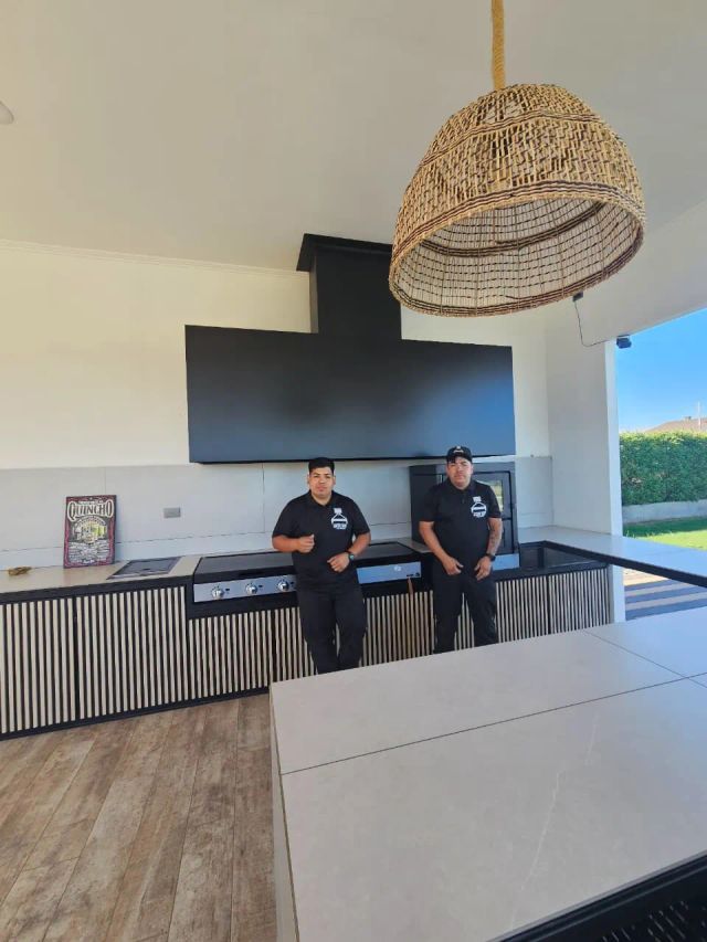 Dos instaladores bajo una campana negra junto a una terraza
