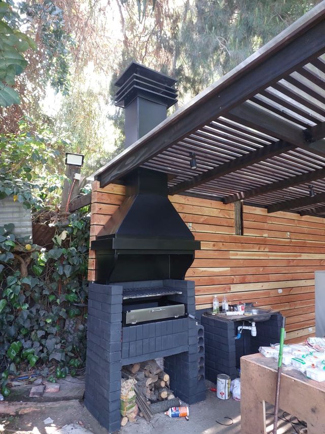 Campana piramidal con chimenea junto a una pared de listones