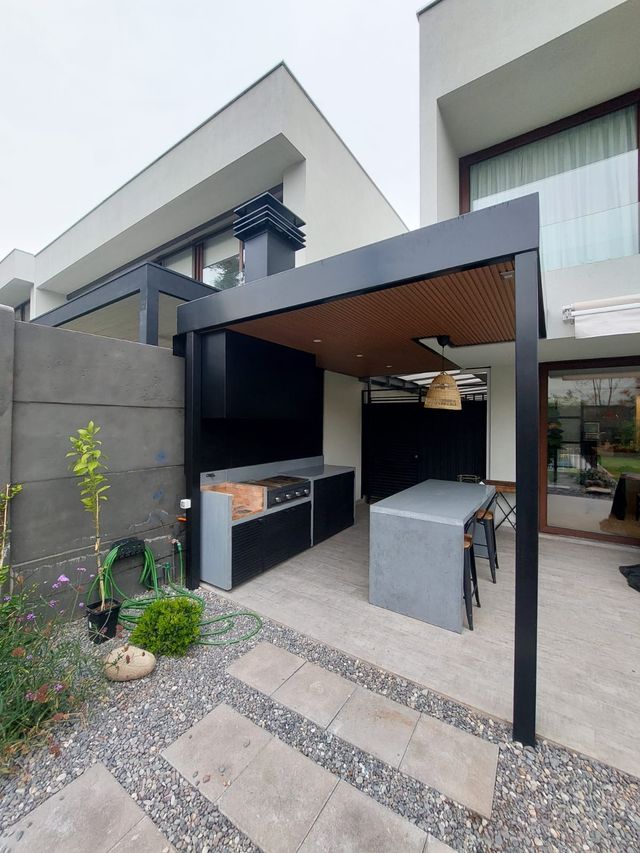 Casa moderna con quincho exterior y campana negra