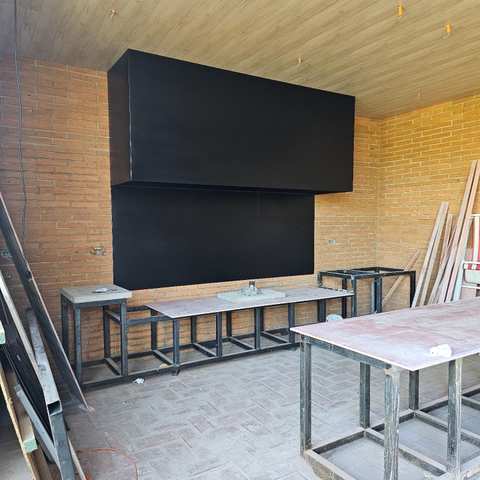 Campana mediterránea rectangular de dos volúmenes sobre un muro de ladrillo