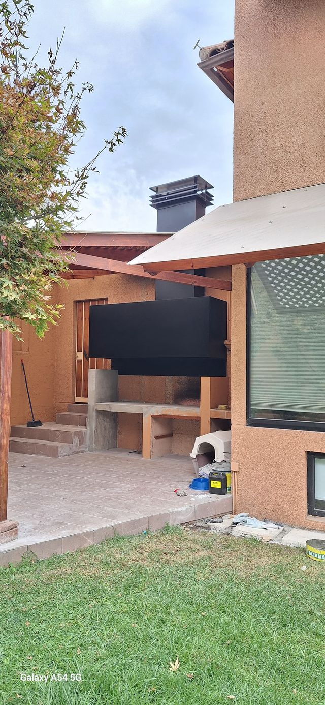 Quincho exterior de ladrillo con campana rectangular, en terminaciones