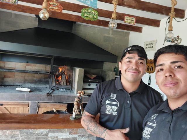 Instalador junto a una campana con el fogón encendido