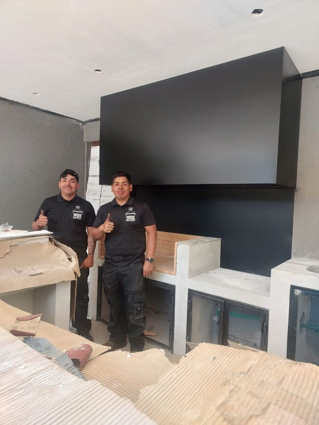 Dos instaladores bajo una campana rectangular negra recién montada