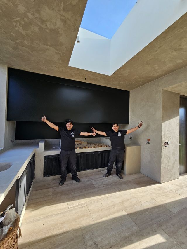 Dos instaladores celebrando bajo una campana rectangular con tragaluz
