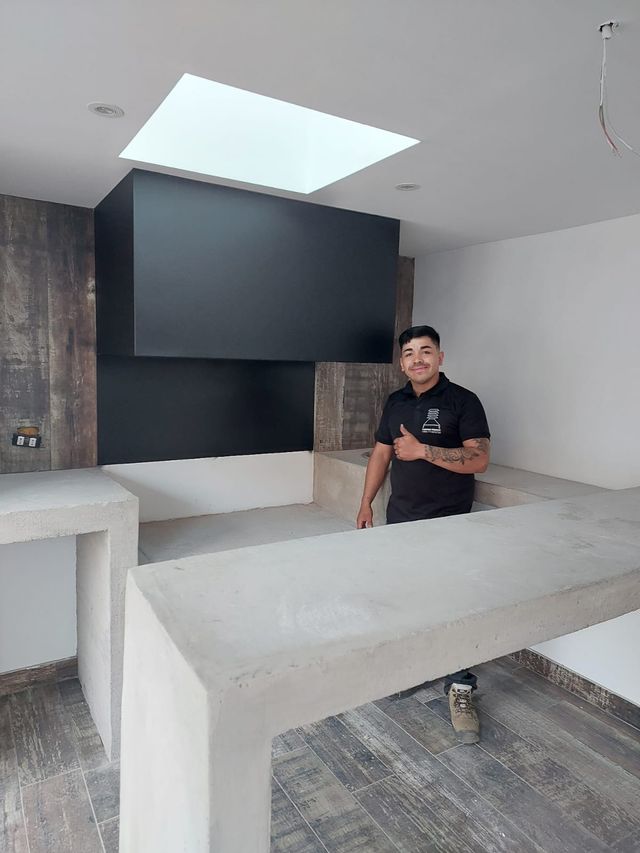 Instalador junto a una campana rectangular, bajo un tragaluz
