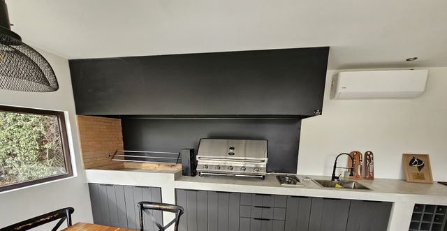 Campana mediterránea sobre parrilla a gas en quincho interior