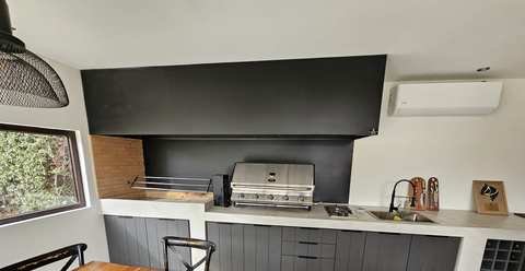 Campana rectangular negra sobre una parrilla a gas