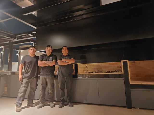 Equipo de Campanas Premium frente a una cocina exterior con campana rectangular
