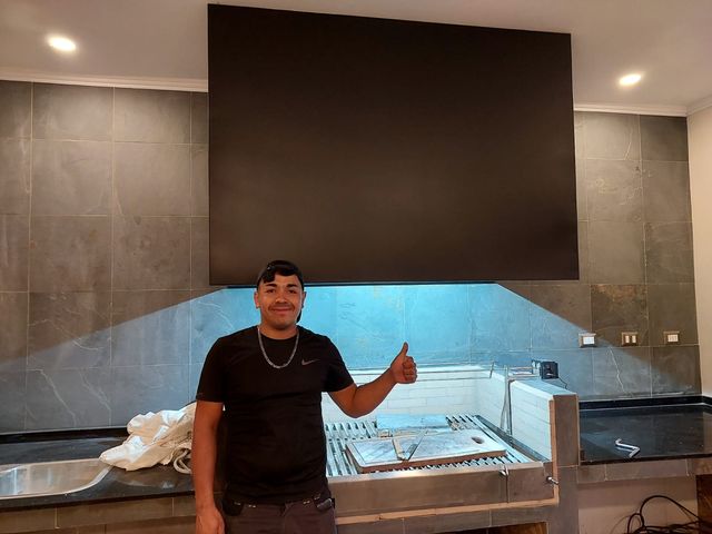 Instalador junto a una campana rectangular con iluminación inferior