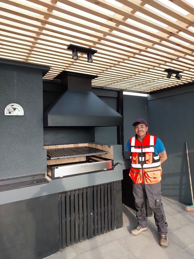 Instalador junto a una campana piramidal sobre parrilla