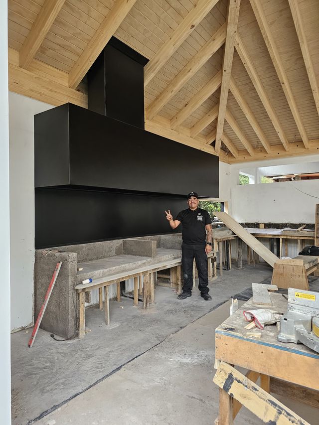 Campana rectangular de gran formato bajo techo de madera, con instalador