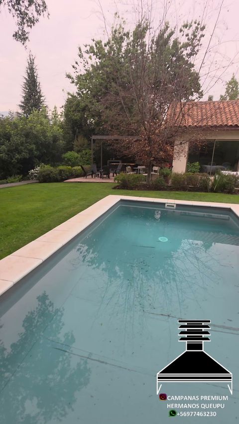 Piscina y jardín de una casa con quincho