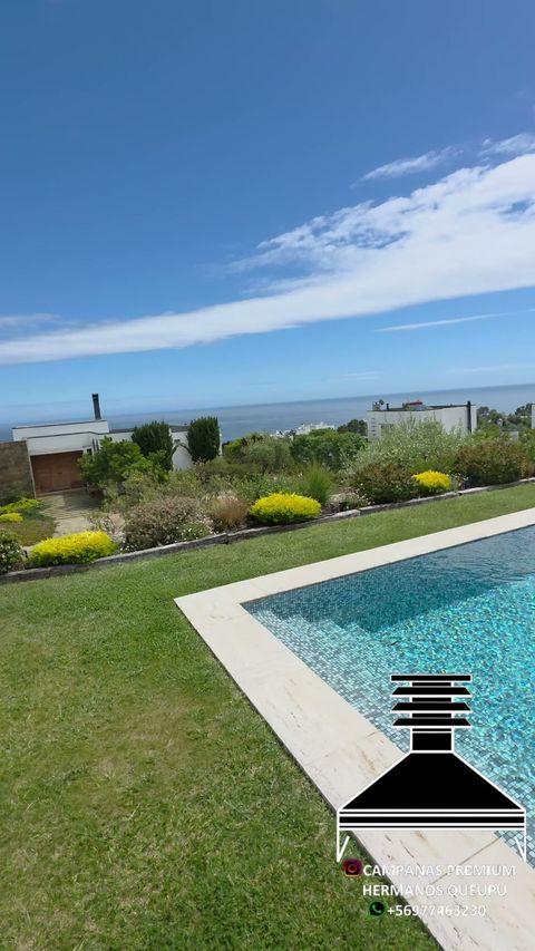 Jardín con piscina y vista al mar en un proyecto con quincho