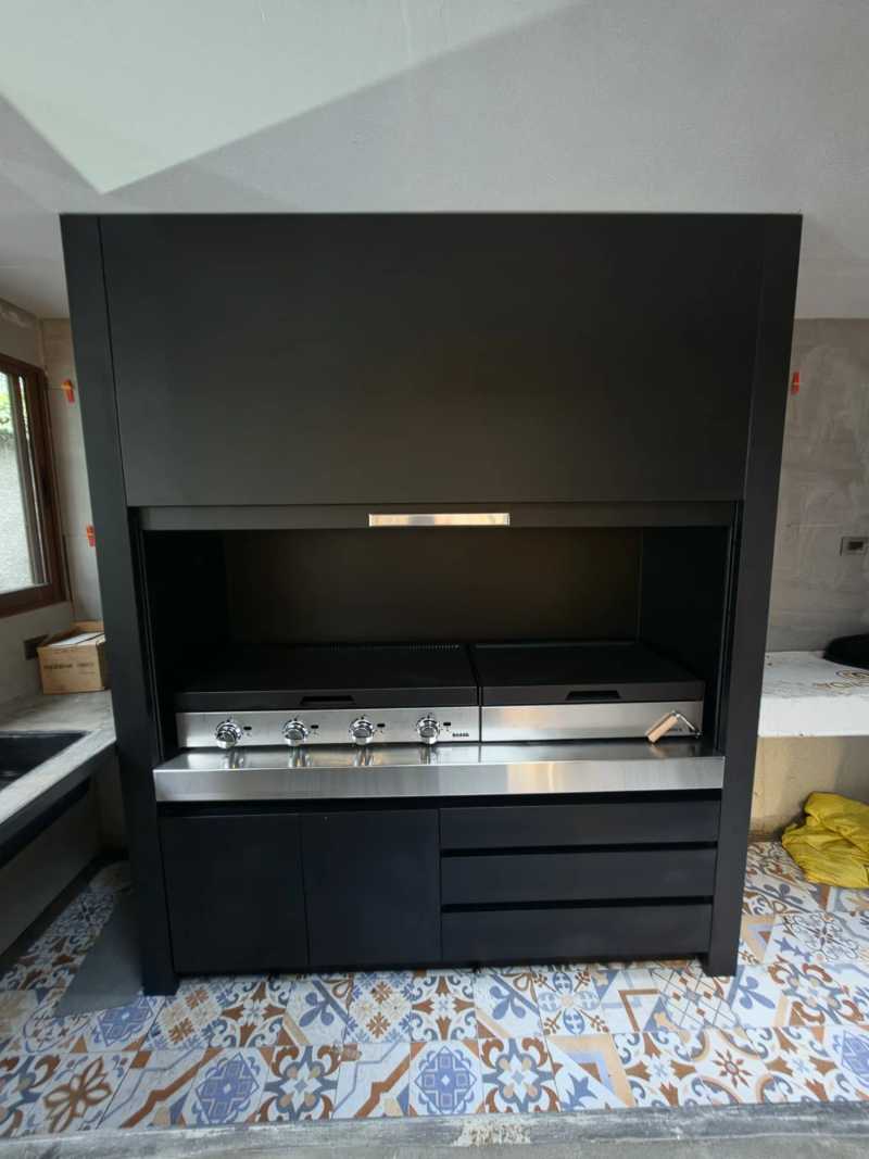 Quincho modular de frente: campana, parrillas de acero y mueble inferior con puertas