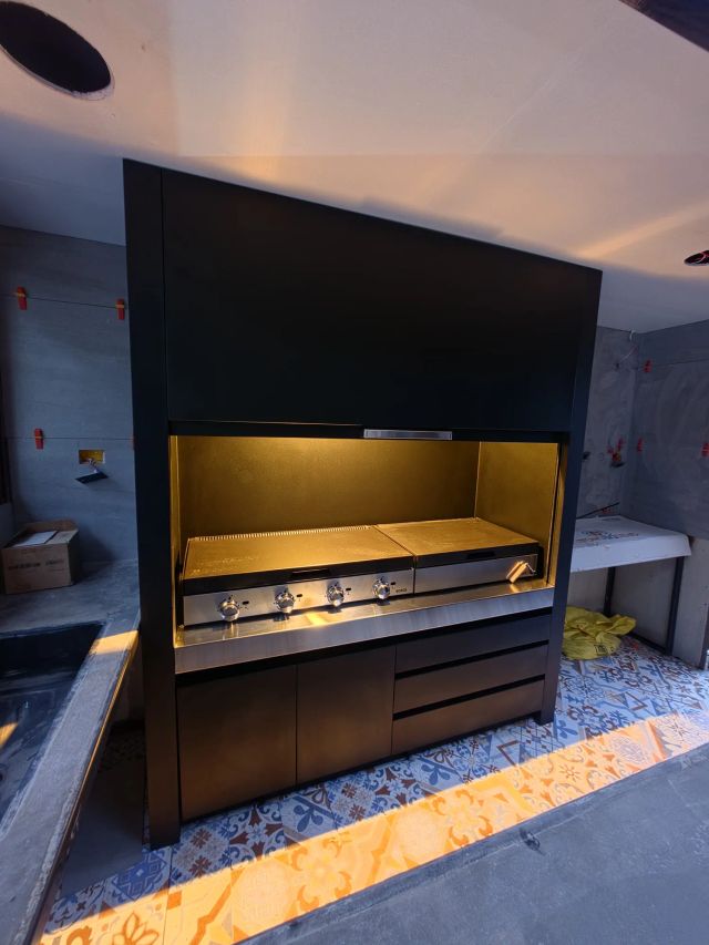 Quincho modular iluminado visto de frente, con la puerta guillotina arriba
